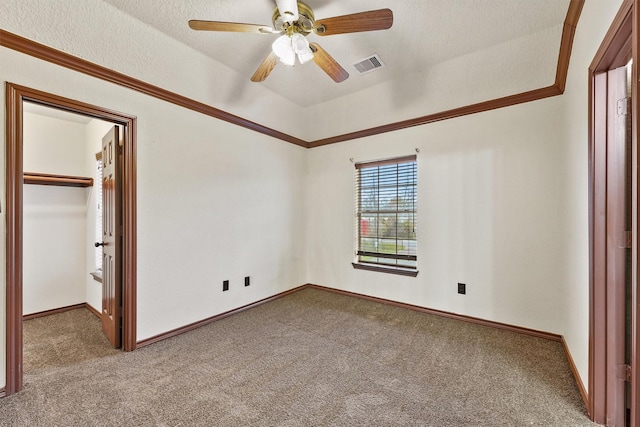 unfurnished bedroom featuring ceiling fan, carpet, a spacious closet, and a closet