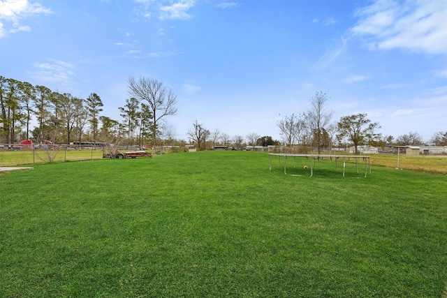 view of yard with a trampoline and a rural view