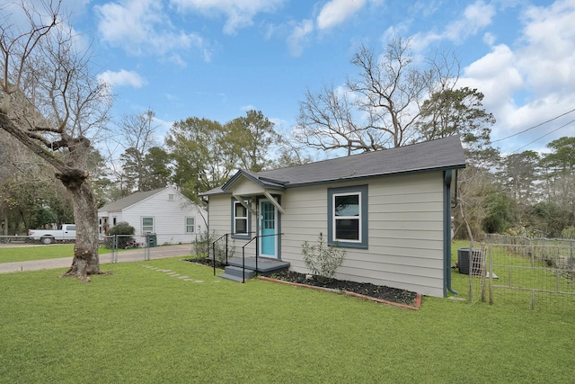 bungalow-style house with a front lawn and central air condition unit