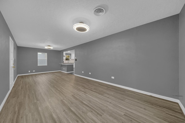 spare room featuring wood-type flooring and a textured ceiling