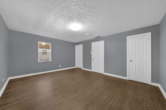 unfurnished bedroom with dark wood-type flooring and a textured ceiling