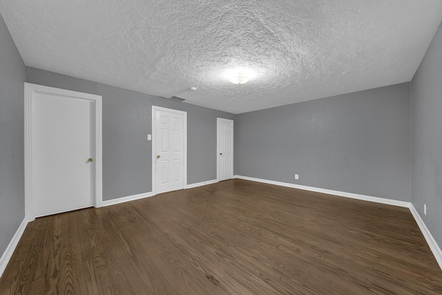 additional living space with a textured ceiling and dark hardwood / wood-style floors