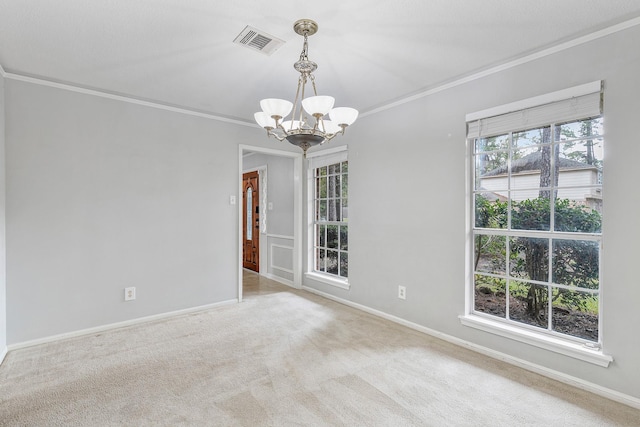 spare room with light colored carpet, ornamental molding, and a chandelier