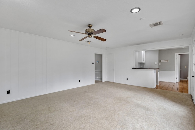 unfurnished living room with ceiling fan and carpet flooring