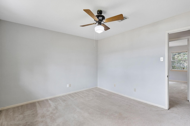 spare room with ceiling fan and light carpet