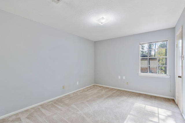 spare room with a textured ceiling and light carpet