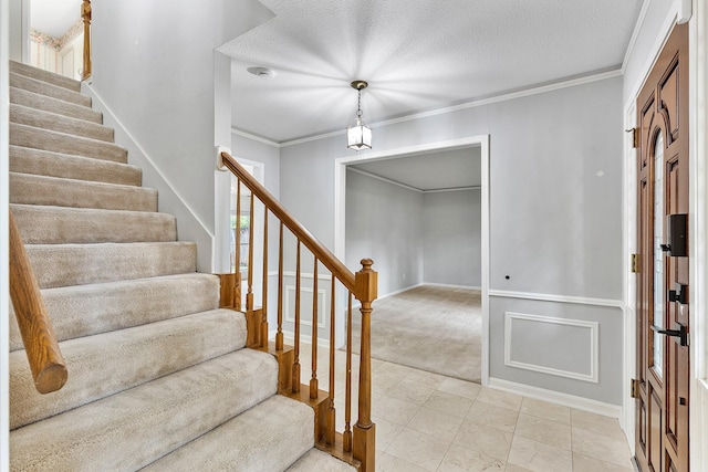 carpeted entrance foyer featuring crown molding and a textured ceiling