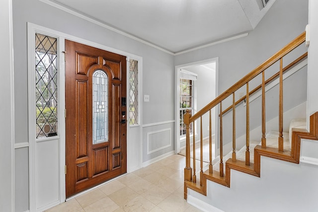 entryway featuring light tile patterned floors, a wealth of natural light, and ornamental molding