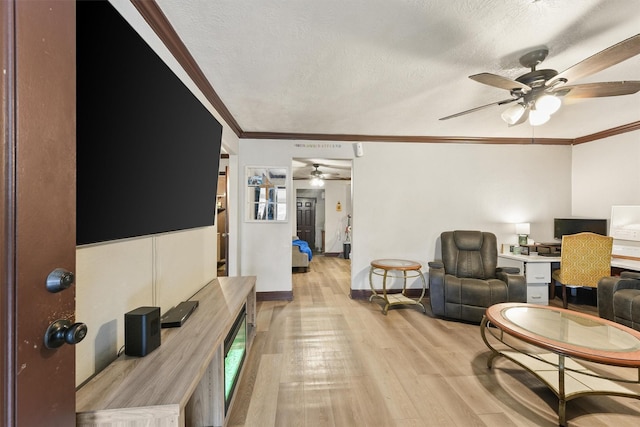 living room featuring light wood-type flooring, a textured ceiling, and ornamental molding