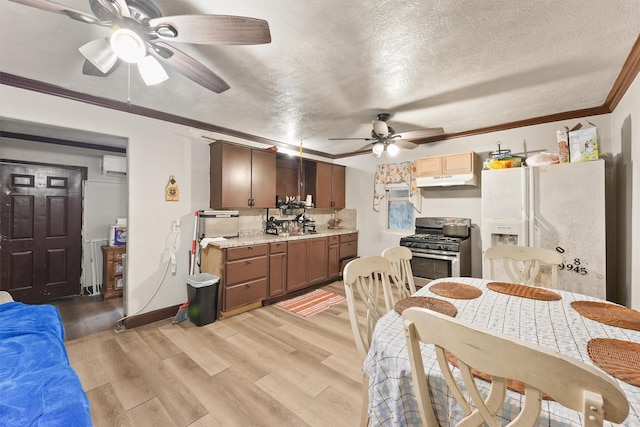 kitchen featuring gas stove, ornamental molding, white refrigerator with ice dispenser, light hardwood / wood-style flooring, and an AC wall unit