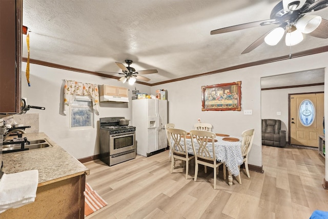 kitchen with sink, stainless steel range with gas stovetop, light hardwood / wood-style flooring, white refrigerator with ice dispenser, and a textured ceiling