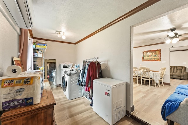 laundry room featuring separate washer and dryer, a textured ceiling, ornamental molding, ceiling fan, and light hardwood / wood-style flooring