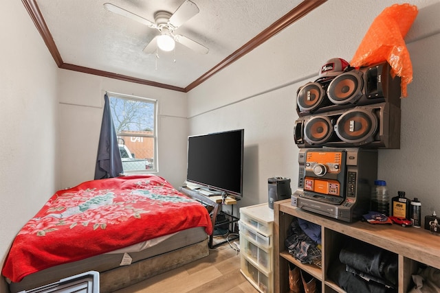 bedroom with ceiling fan, a textured ceiling, crown molding, and light wood-type flooring