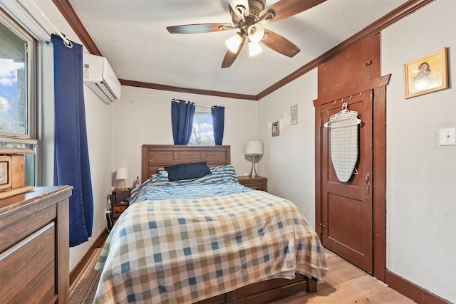 bedroom featuring ceiling fan, crown molding, light hardwood / wood-style flooring, a wall mounted air conditioner, and a textured ceiling