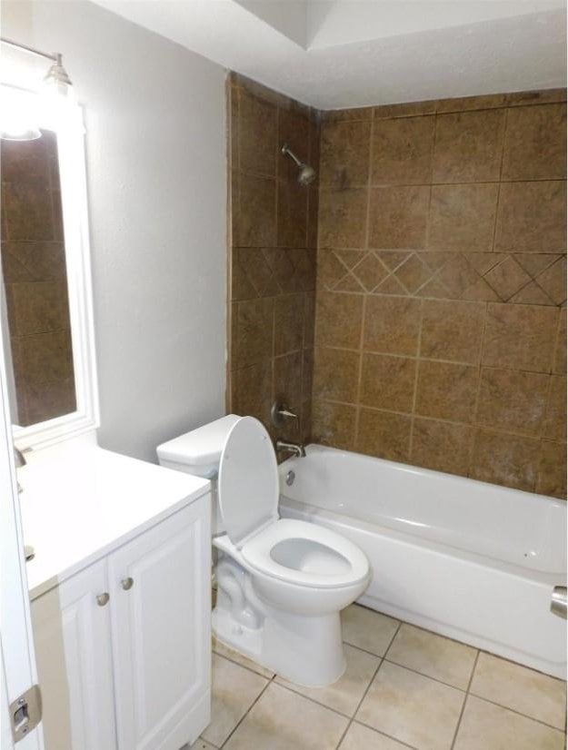 full bathroom featuring toilet, vanity, tiled shower / bath, and tile patterned flooring