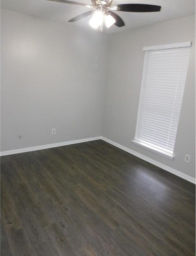 unfurnished room featuring ceiling fan and dark hardwood / wood-style flooring