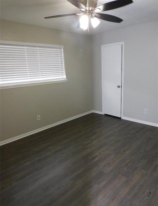 unfurnished room featuring ceiling fan and dark hardwood / wood-style flooring