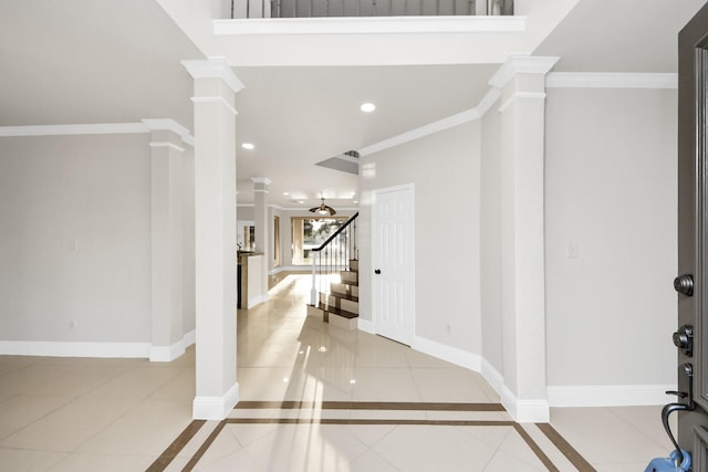 tiled entrance foyer featuring ornamental molding and ornate columns