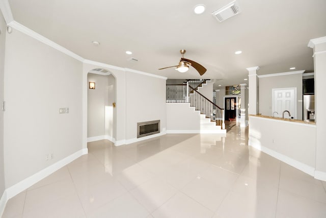 unfurnished living room with ceiling fan, light tile patterned floors, and crown molding