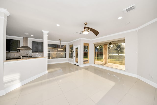 unfurnished living room featuring ceiling fan, light tile patterned floors, crown molding, and sink