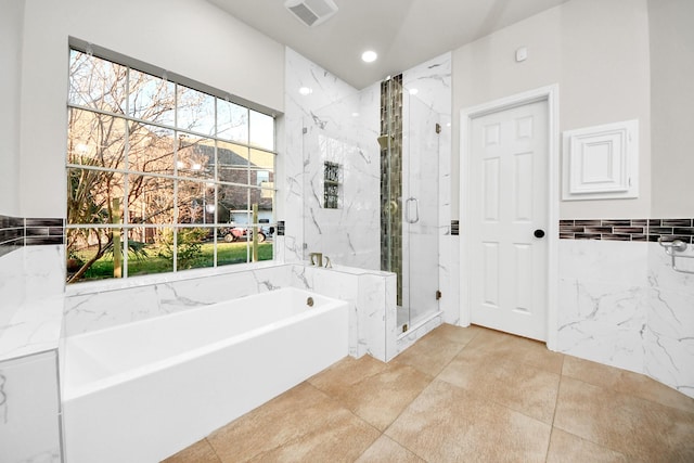 bathroom featuring shower with separate bathtub