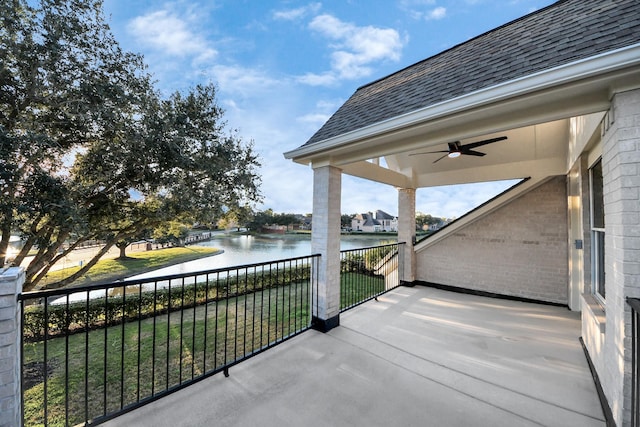 balcony with ceiling fan and a water view