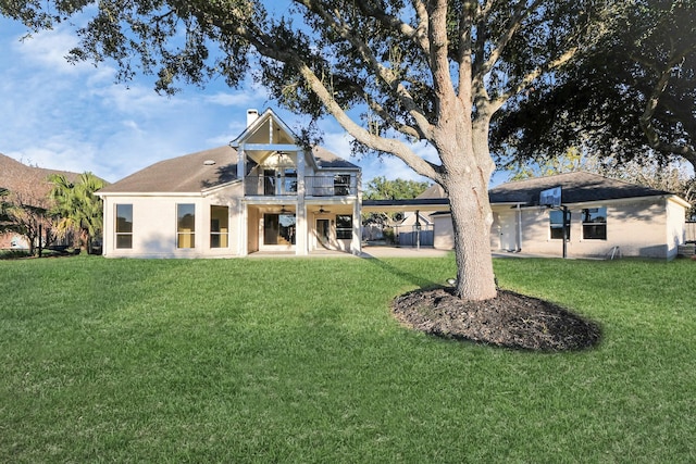 rear view of house featuring a patio, a balcony, and a yard