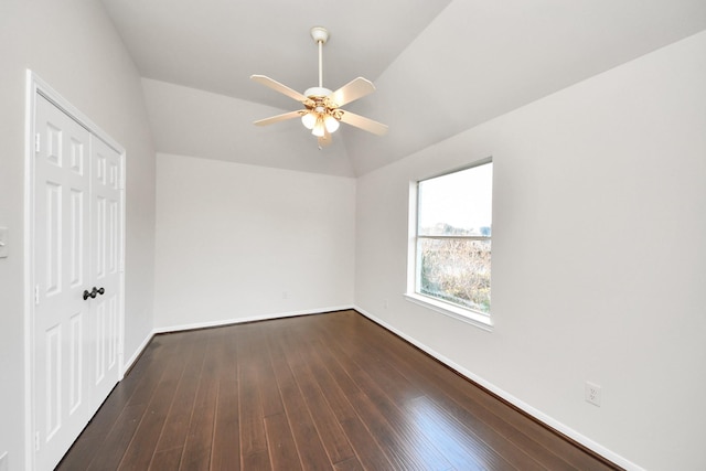 unfurnished bedroom featuring ceiling fan, dark hardwood / wood-style flooring, a closet, and vaulted ceiling