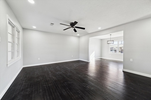 unfurnished living room with dark hardwood / wood-style flooring and ceiling fan with notable chandelier