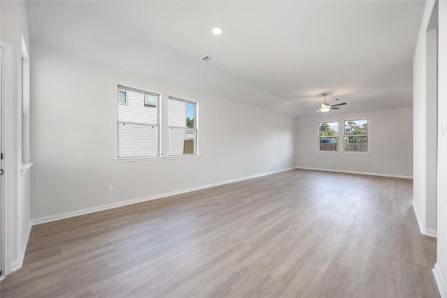 empty room with light wood-type flooring, ceiling fan, and lofted ceiling