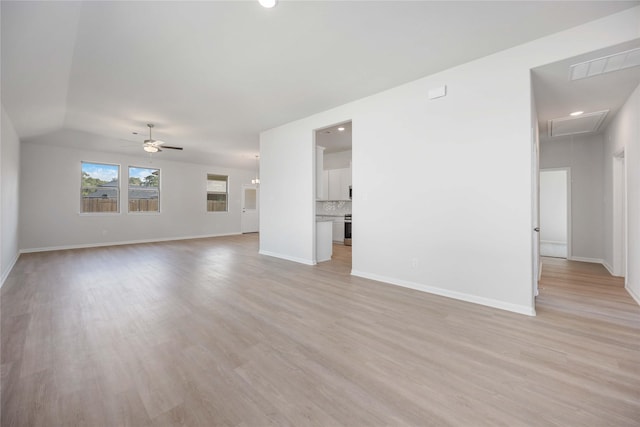 unfurnished living room featuring ceiling fan, light wood-type flooring, and vaulted ceiling