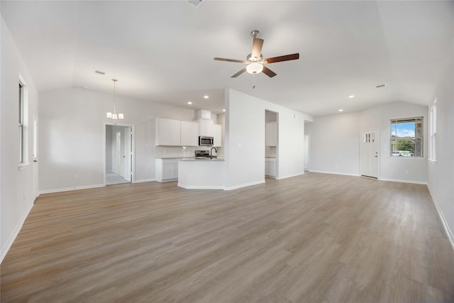 unfurnished living room with vaulted ceiling, ceiling fan, and light wood-type flooring