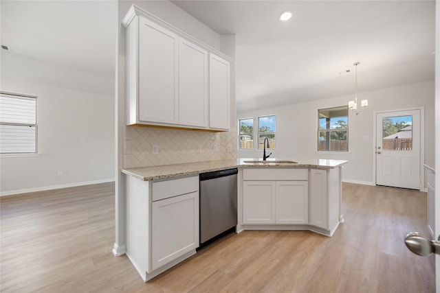 kitchen with pendant lighting, dishwasher, white cabinetry, tasteful backsplash, and sink