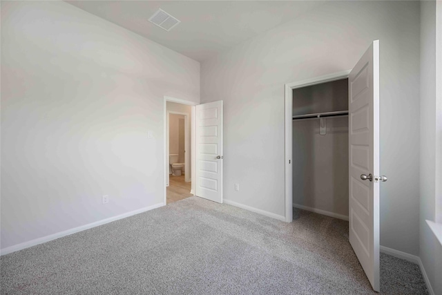 unfurnished bedroom featuring a closet and light carpet