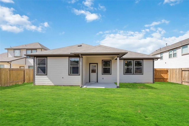 back of property with a yard and a patio