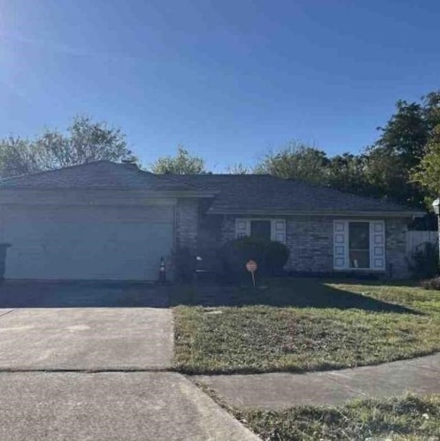 single story home with an attached garage, concrete driveway, and a front yard