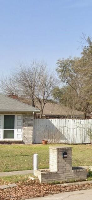 exterior space with fence and a front lawn