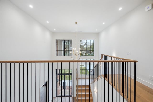 hall featuring hardwood / wood-style floors and a notable chandelier