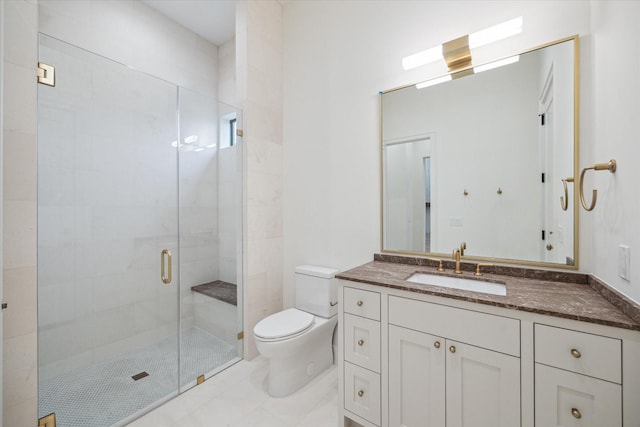 bathroom featuring vanity, a shower with door, and toilet