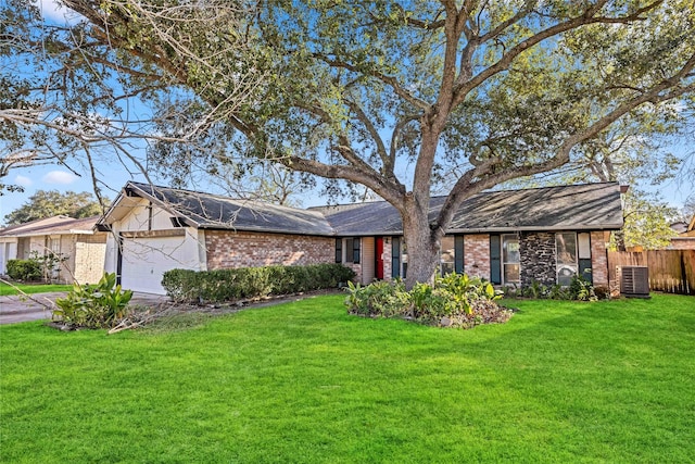 single story home with a front lawn, central AC unit, and a garage