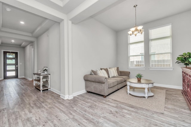 living room with light wood-type flooring and an inviting chandelier