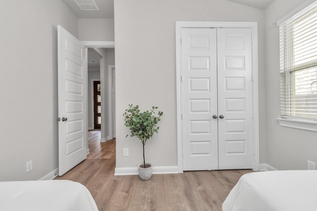 bedroom with a closet and light hardwood / wood-style flooring