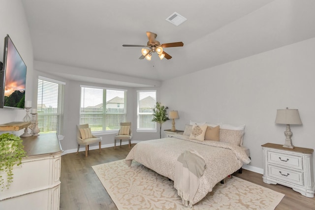 bedroom with ceiling fan, hardwood / wood-style floors, and lofted ceiling