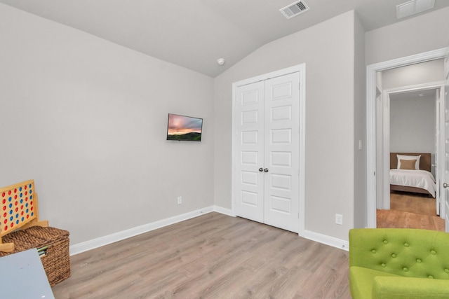 unfurnished room featuring light hardwood / wood-style flooring and vaulted ceiling