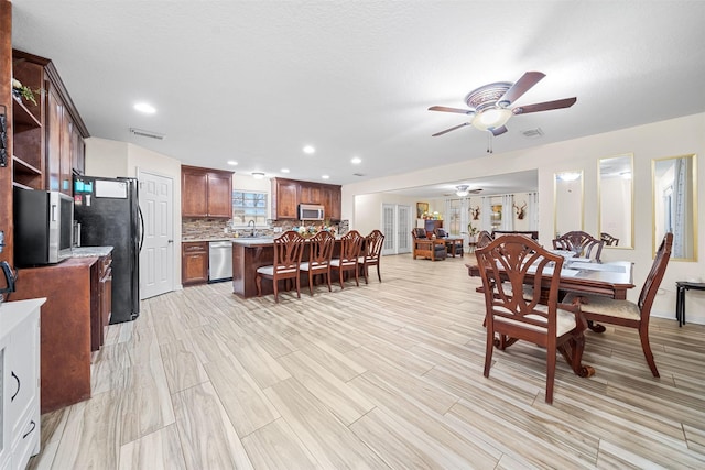 dining area featuring ceiling fan, sink, and light hardwood / wood-style floors