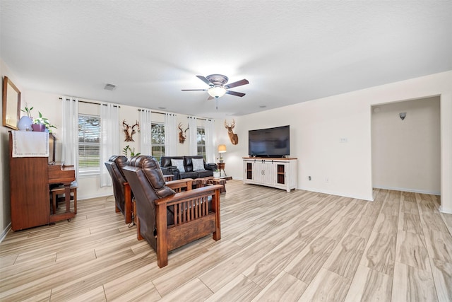 living room featuring ceiling fan and light hardwood / wood-style floors