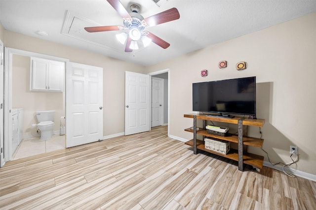 interior space with ceiling fan, connected bathroom, and light hardwood / wood-style floors