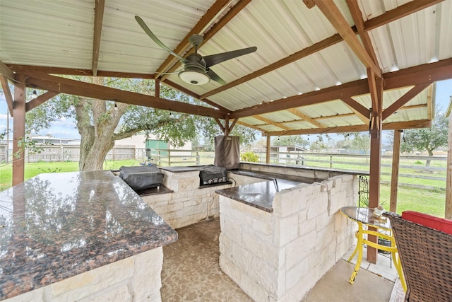 view of patio / terrace with ceiling fan, exterior bar, and area for grilling