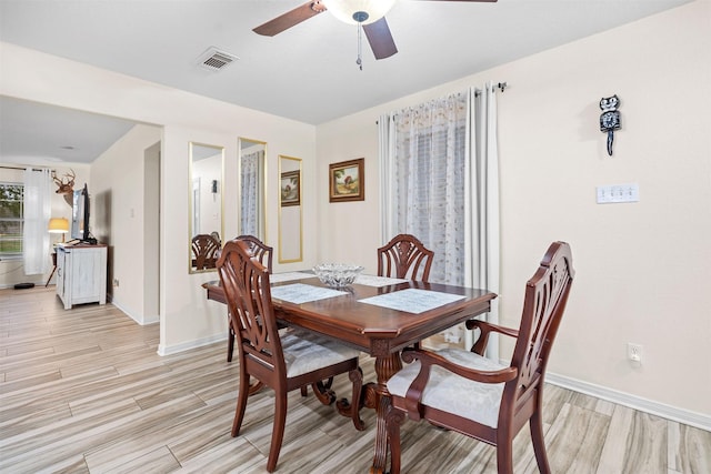 dining space with ceiling fan and light hardwood / wood-style flooring