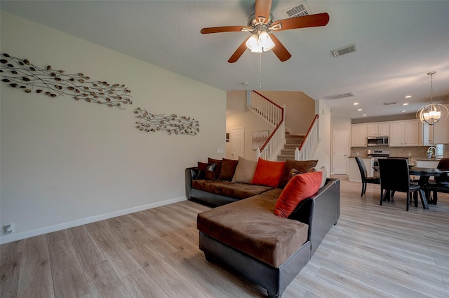 living room featuring ceiling fan, light hardwood / wood-style floors, and sink